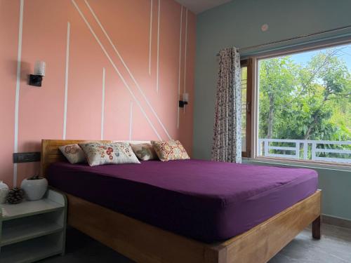a bedroom with a purple bed with a window at Terra Himalayan Homestay in Kasar Devi in Hawālbāgh