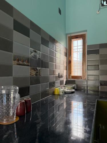 a kitchen with black and gray tiles on the floor at Terra Himalayan Homestay in Kasar Devi in Hawālbāgh