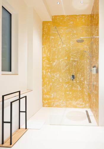 a bathroom with a shower with a gold wall at MINTNaschmarkt in Vienna