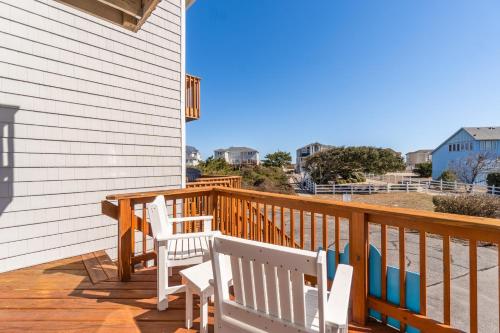 two white chairs sitting on a wooden deck at 4203 - Here Comes the Sun in Duck