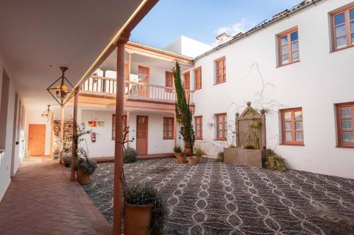 a courtyard of a white building with potted plants at Cordoba Calle Pozanco in Córdoba