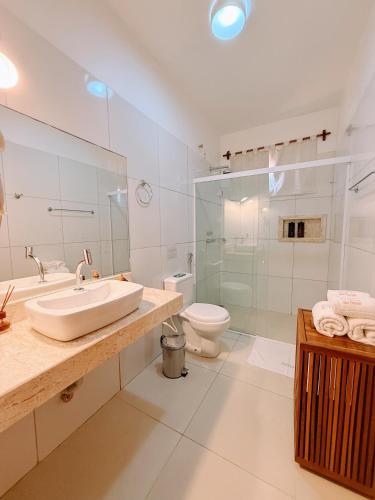 a bathroom with a sink and a toilet and a shower at Pousada Jeri Dunas in Jericoacoara