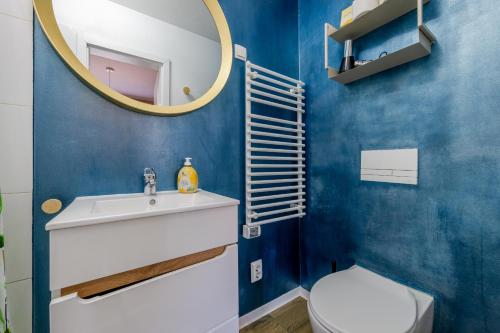 a bathroom with a sink and a mirror and a toilet at Gemütliche Ferienwohnung - Araliya 2 in Ahlbeck