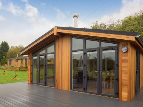 a house with glass doors on a deck at Cedar Lodge in Hassocks