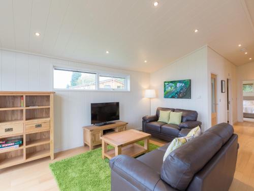 a living room with a couch and a tv at Cedar Lodge in Hassocks