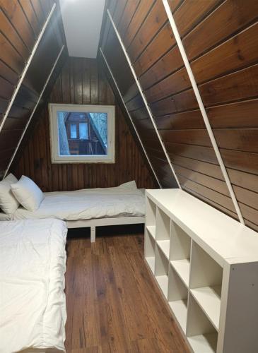 a room with two beds in a wooden house at Brda Hideaway in Głębokie