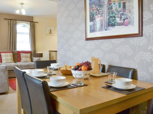 a dining room table with a bowl of fruit on it at Eldin Hall Cottage 2 - Uk2484 in Scarborough