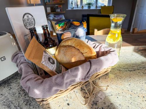 a basket of bread and bottles of beer on a table at The Helmsley Retreat in Helmsley