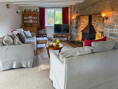 a living room with two couches and a fireplace at Prideaux Cottage in Par