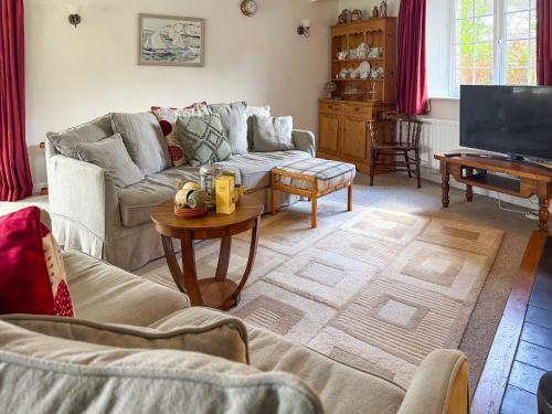 a living room with a couch and a table at Prideaux Cottage in Par