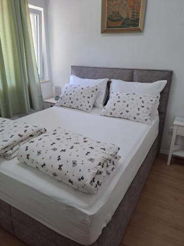a bedroom with a large bed with black and white pillows at Apartment Kazela in Split