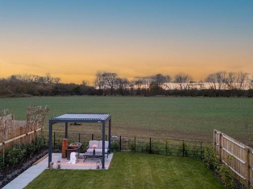 a gazebo on a lawn with a field at Uk47692 - Wiggles Cottage in Wimbish