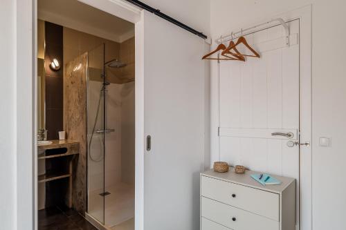 a bathroom with a shower and a glass door at Cozy Suite À Da Marina in Quinta do Poço