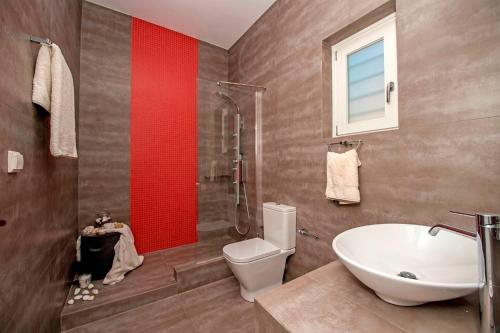 a bathroom with a white toilet and a sink at villa zakintos in Aspro Chorio Paros
