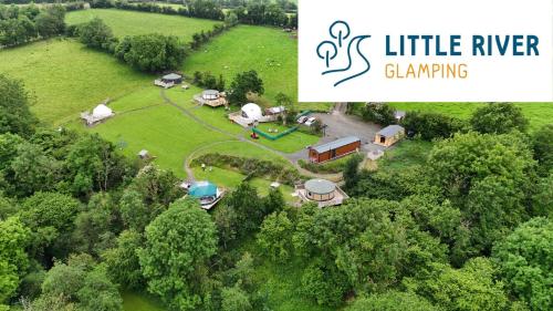 an aerial view of a farm with a house and trees at Little River Glamping in Ballymoney