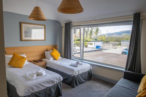 a hotel room with two beds and a large window at Callander Hostel in Callander