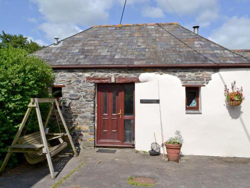 a small stone cottage with a red door at Ross in Launceston