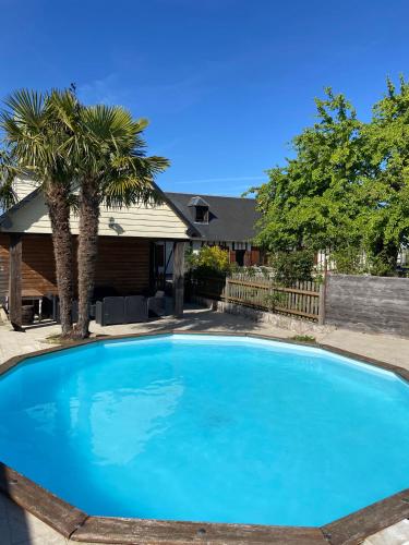 a large blue swimming pool in a yard at Villa 1h30 de Paris - Padel - Piscine - 7 ch - 22 pers in Épinay