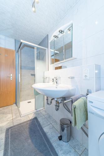 a white bathroom with a sink and a shower at Apparthaus Schuchter in Silbertal