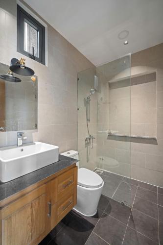 a bathroom with a sink and a toilet and a shower at Doris Entire House Da Nang in Danang