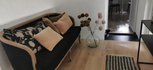 a couch with pillows on it in a living room at Chez Ariel et Myrtille in Bruyères