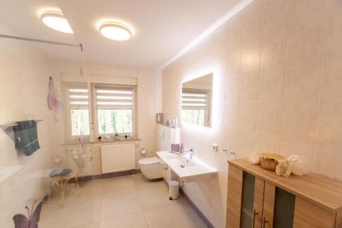 a white bathroom with a sink and a toilet at Ferienwohnung Familie Täubert in Klein Uhyst