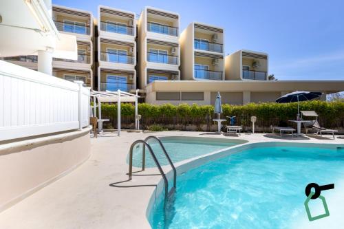 a swimming pool in front of a building at Hotiday Alghero Spiaggia in Alghero
