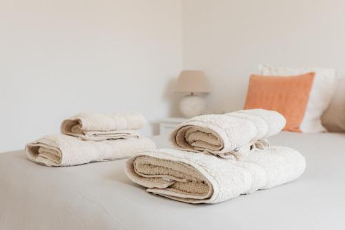 a pile of towels sitting on top of a bed at ALOJAMIENTO ARENAL PARK in Jávea