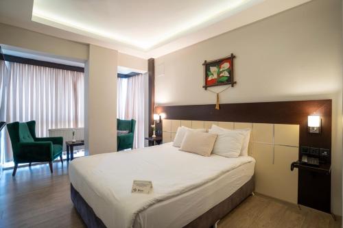 a hotel room with a bed and a desk and chairs at Buyuk Velic Hotel in Gaziantep