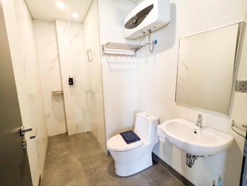 a white bathroom with a toilet and a sink at Lovina 7-AA at One Residence in Batam Center
