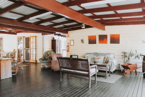 a living room with chairs and a couch and a table at Glasshouse Mountains Ecolodge in Glass House Mountains