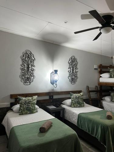 a room with two beds and a ceiling fan at Windpomp Guesthouse in Beaufort West