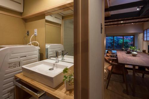 a bathroom with a sink and a dining room at Shimabara Kaiden Machiya House in Kyoto