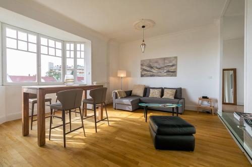a living room with a table and a couch at Le Victor Hugo in Dijon
