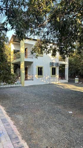 a large white house sitting on top of a driveway at Chandan resort in Chitrāwal