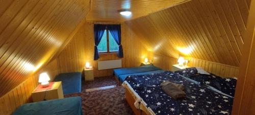 a room with a bed and two chairs and a window at Chalupka pod Kozincom - Zázrivá in Zázrivá