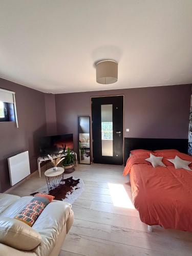 a bedroom with a red bed and a table at Le kesson in Saint-Brieuc