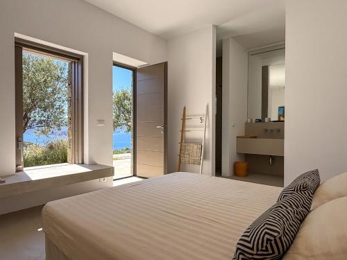 a bedroom with a large bed and a large window at ARETI Horizon in Kástron