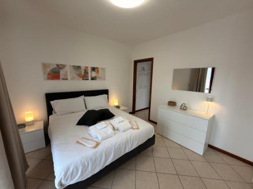 a bedroom with a large white bed and a mirror at Malpensa Stay Express Self check-in in Gallarate
