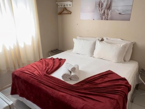 a bed with two rolled up towels on it at Casa do Anjo in Fernando de Noronha