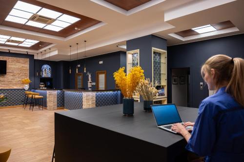 a woman sitting at a table with a laptop at Hotel Moderno in Bari