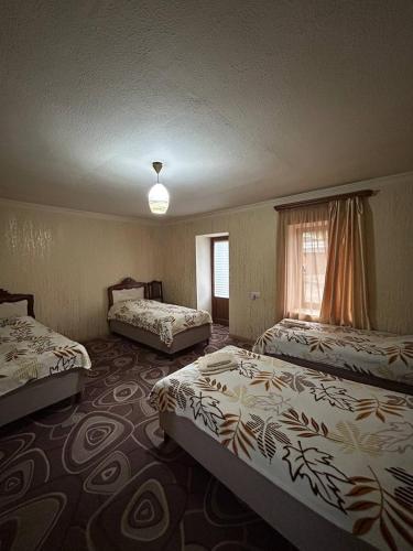 a hotel room with two beds and a window at Lucy Apartment Goris in Goris