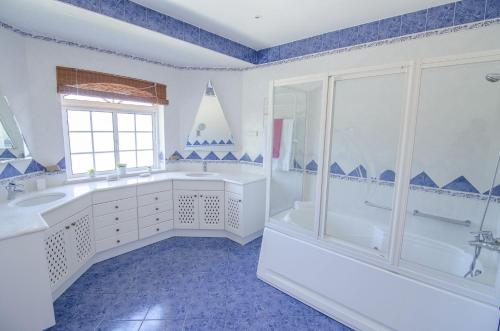 a bathroom with a tub and a sink and a shower at Villa Lira by Algarve Holidays in Almancil