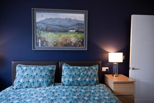 a bedroom with a bed and a painting on the wall at No 3 Central Chambers in Stratford-upon-Avon