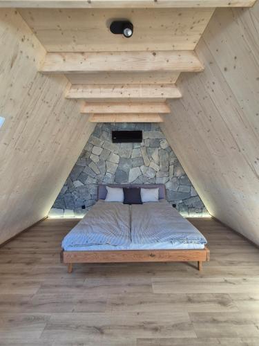 a bed in a room with a stone wall at Silva Peak House in Zawoja