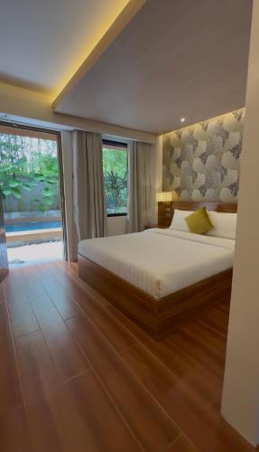 a bedroom with a large bed and a large window at Choox Villa Hotel in Koronadal