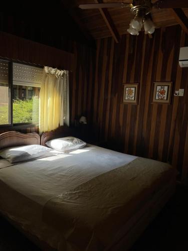 a bedroom with a large bed with a window at Hotel Cabañas Del Parque in Oberá