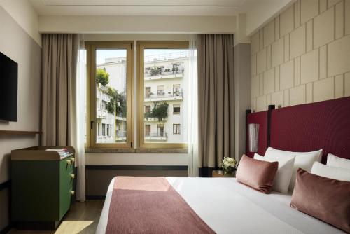 a bedroom with a large bed and a window at Tivoli President Milano Hotel in Milan
