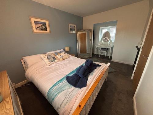 a bedroom with a bed with a blue bow on it at Holly Berry Cottage in Holme next the Sea