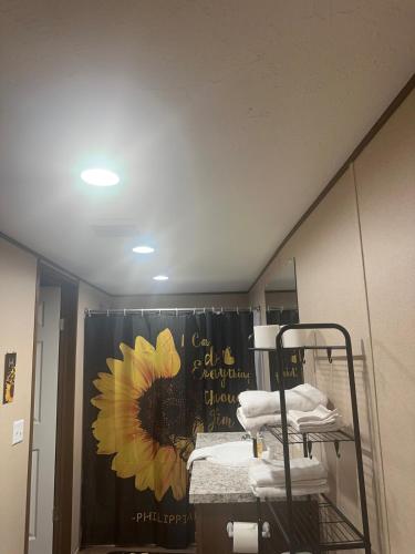 a bathroom with a sunflower shower curtain and a mirror at The Relaxation Haven 